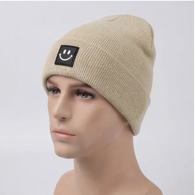 Beige cuffed knit beanie with a black smile label on a mannequin