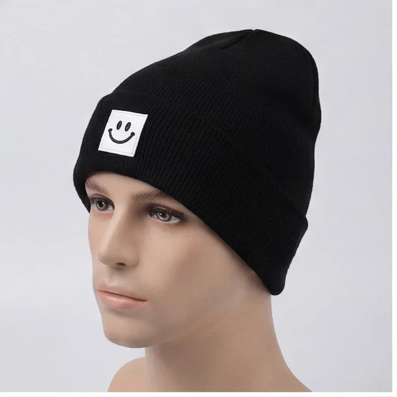 Black cuffed knit beanie with a white smile label on a mannequin