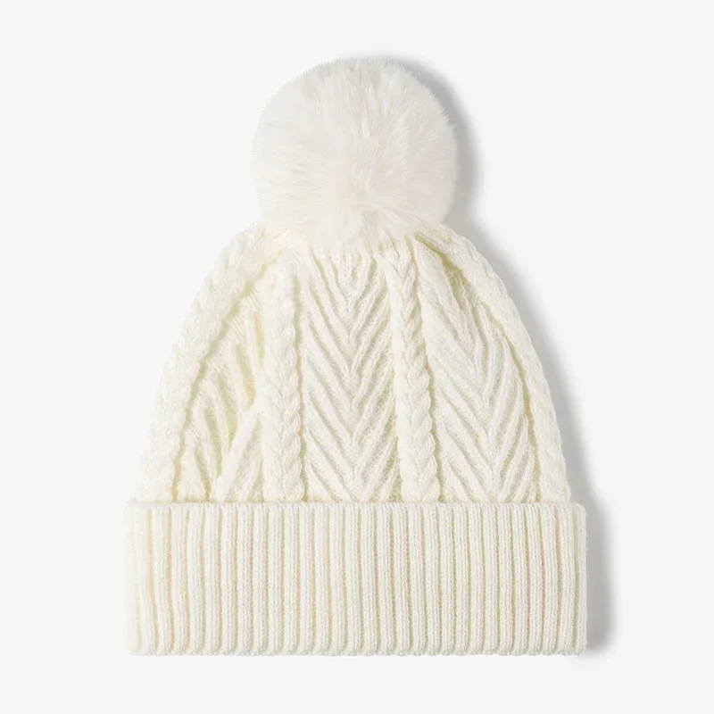 Cream cable knit beanie with a folded ribbed cuff and pale pom pom