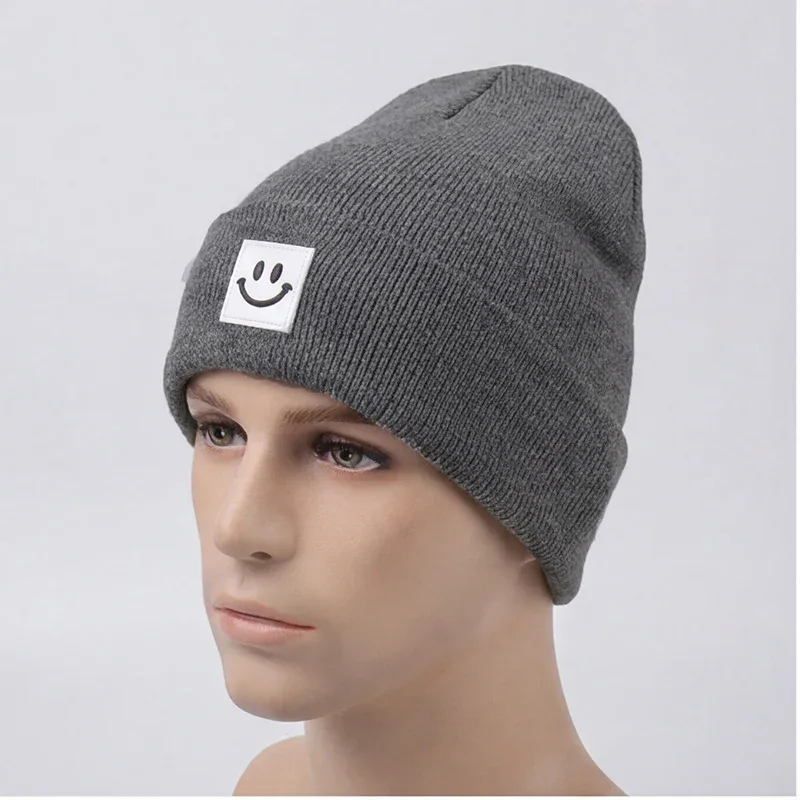 Grey cuffed knit beanie with a black smile label on a mannequin
