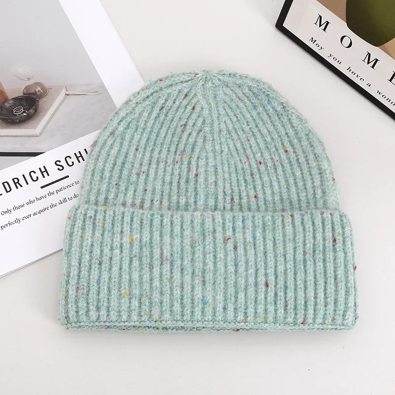 Sage green rib knit beanie with a folded cuff photographed flat
